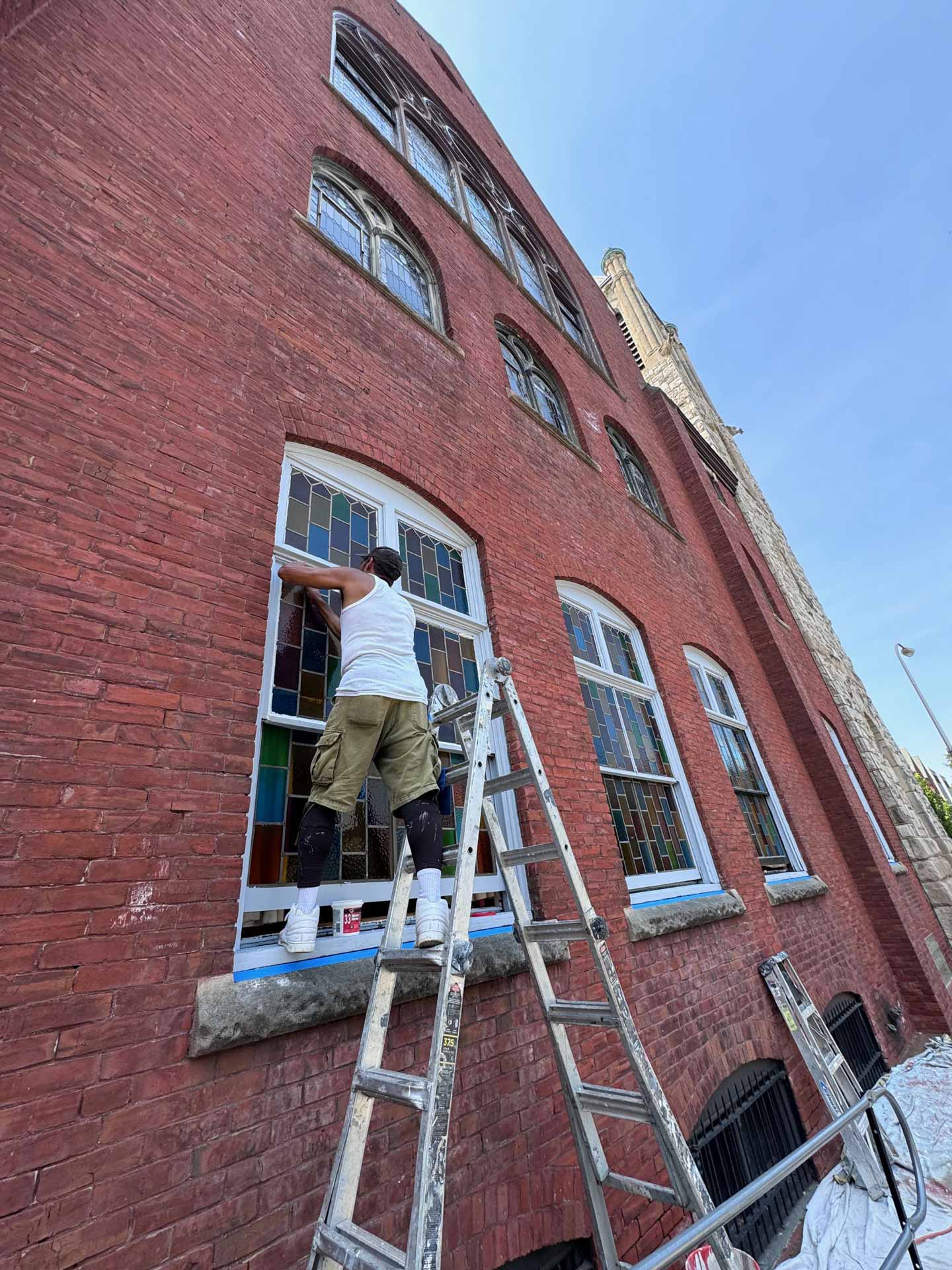 Worker from Philadelphia House Painting painting a window frame
